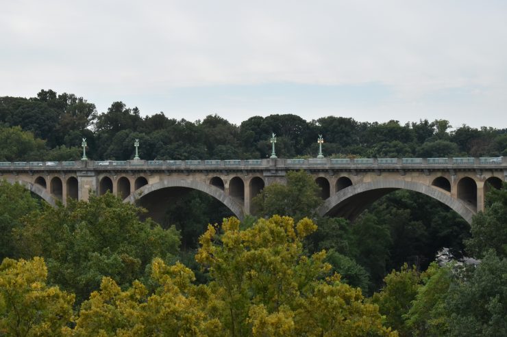 A complete view of the Taft Bridge, surrounded by trees from Rock Creek Park.