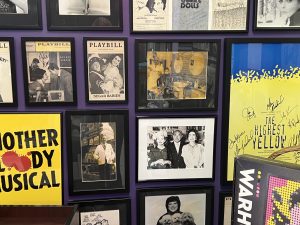 Framed photographs and playbills on a wall