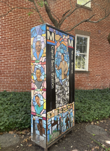 Jabari Jefferson's sculpture, which is a six-foot-tall rectangular prism with colorful images of his family, metro stations like Capitol South and Tacoma, and mosaic-like colors.